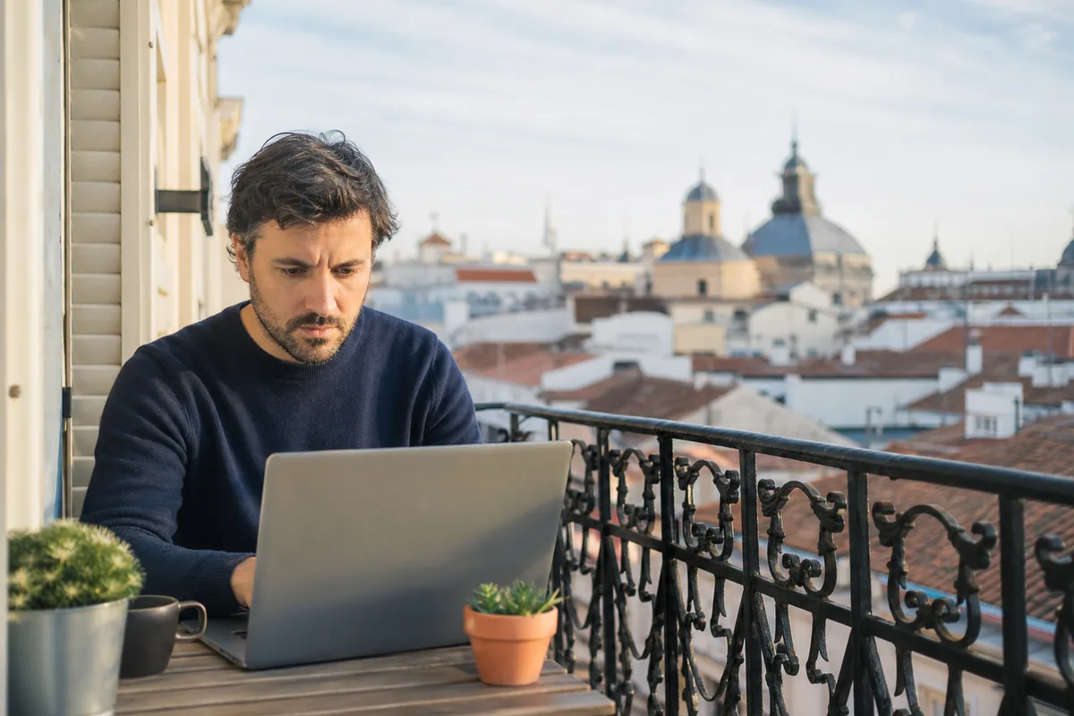 Profissional em trabalho remoto numa varanda em Madri